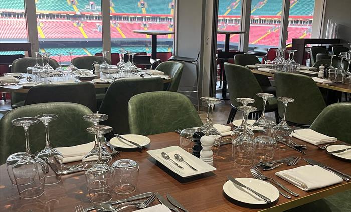 The South Stand Lounge overlooking the Principality Stadium pitch, with stylish seating and panoramic views, set up for a premium matchday hospitality